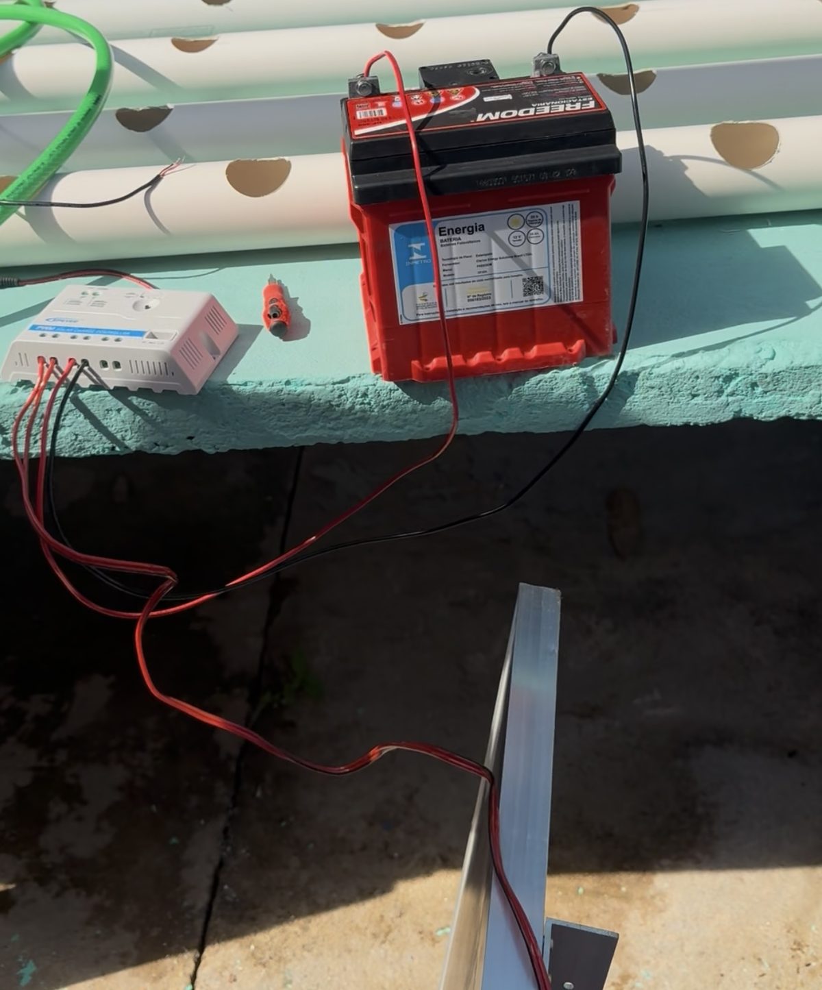 Bateria, controlador de carga e painel solar conectados durante os testes do sistema elétrico